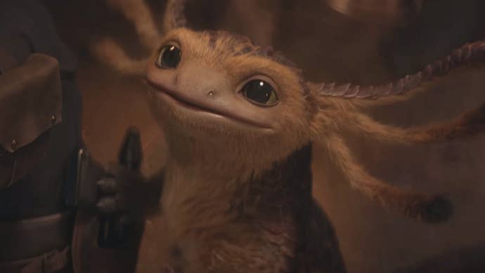 Nix, a small axolotl-like alien in Star Wars Outlaws, looks up curiously to the camera.